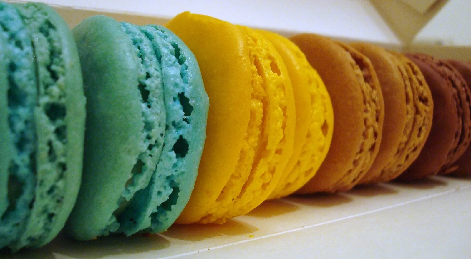 Colourful mint, lemon and coffee macarons in a row