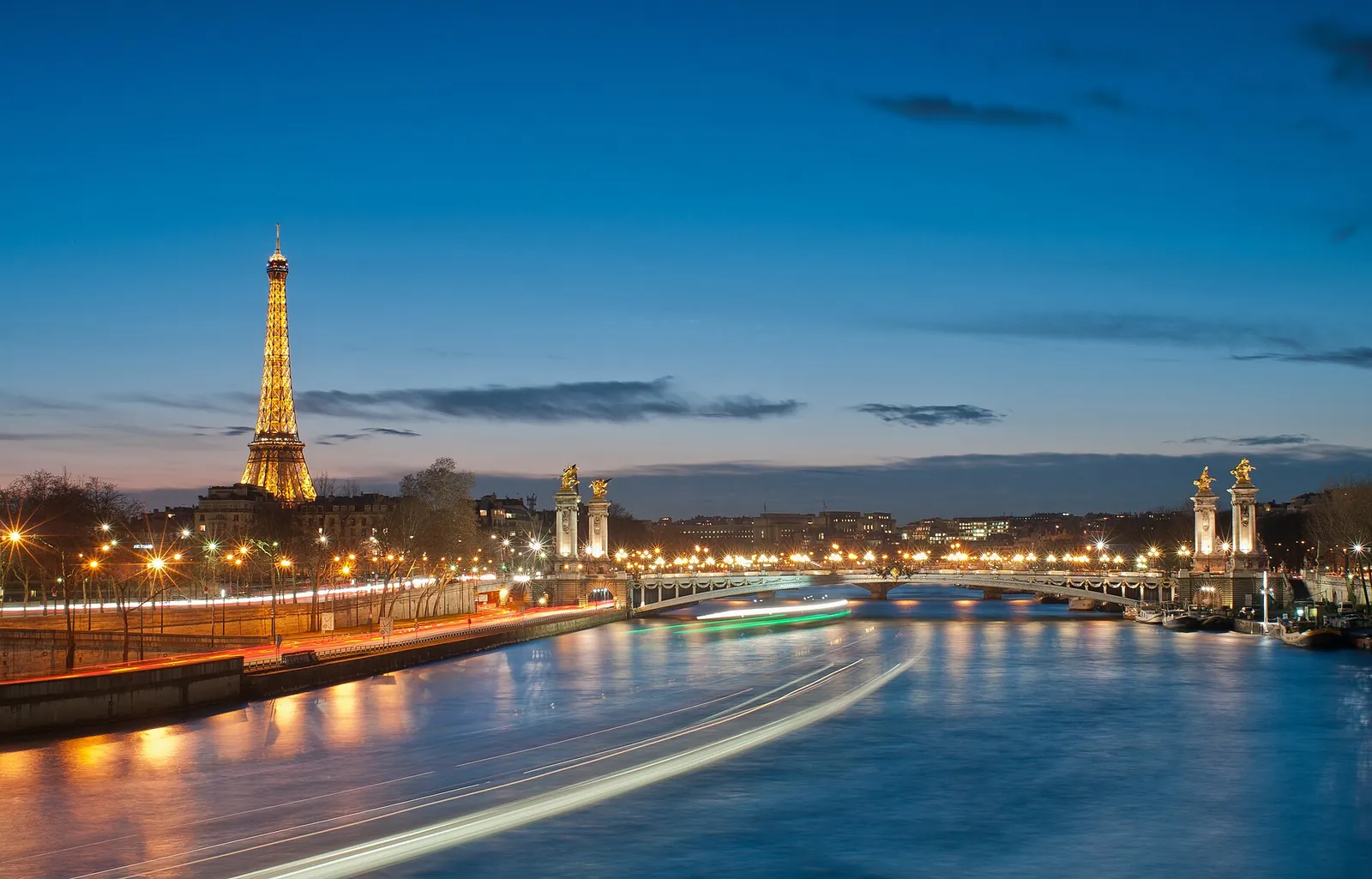 Eiffel Tower and Pont Alexandre III lit up at night