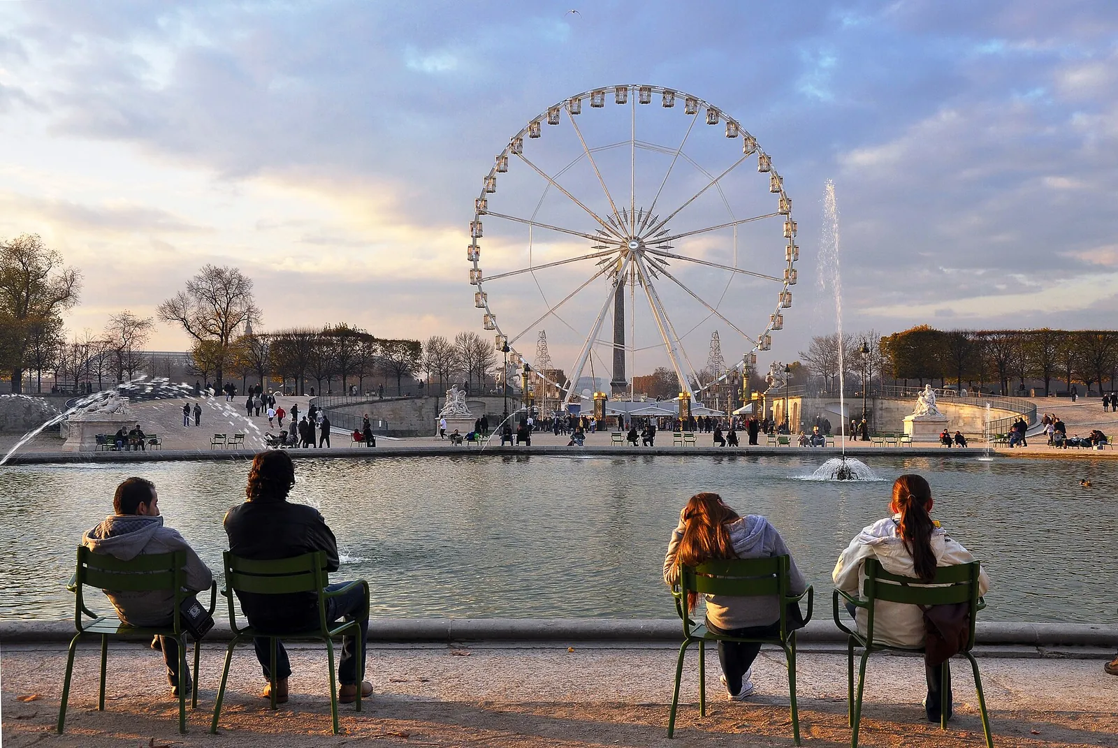 Green chairs by the Tuileries pond and a Ferris wheel