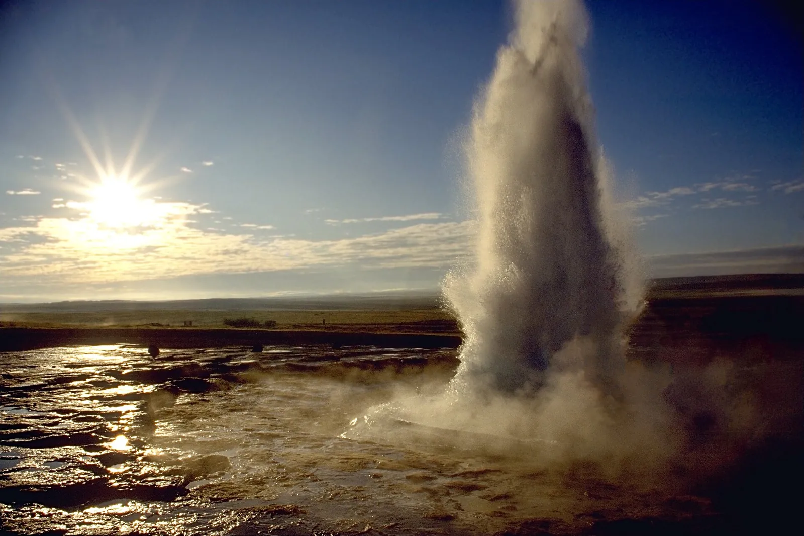 Strokkur geyser shooting up into the sunlight