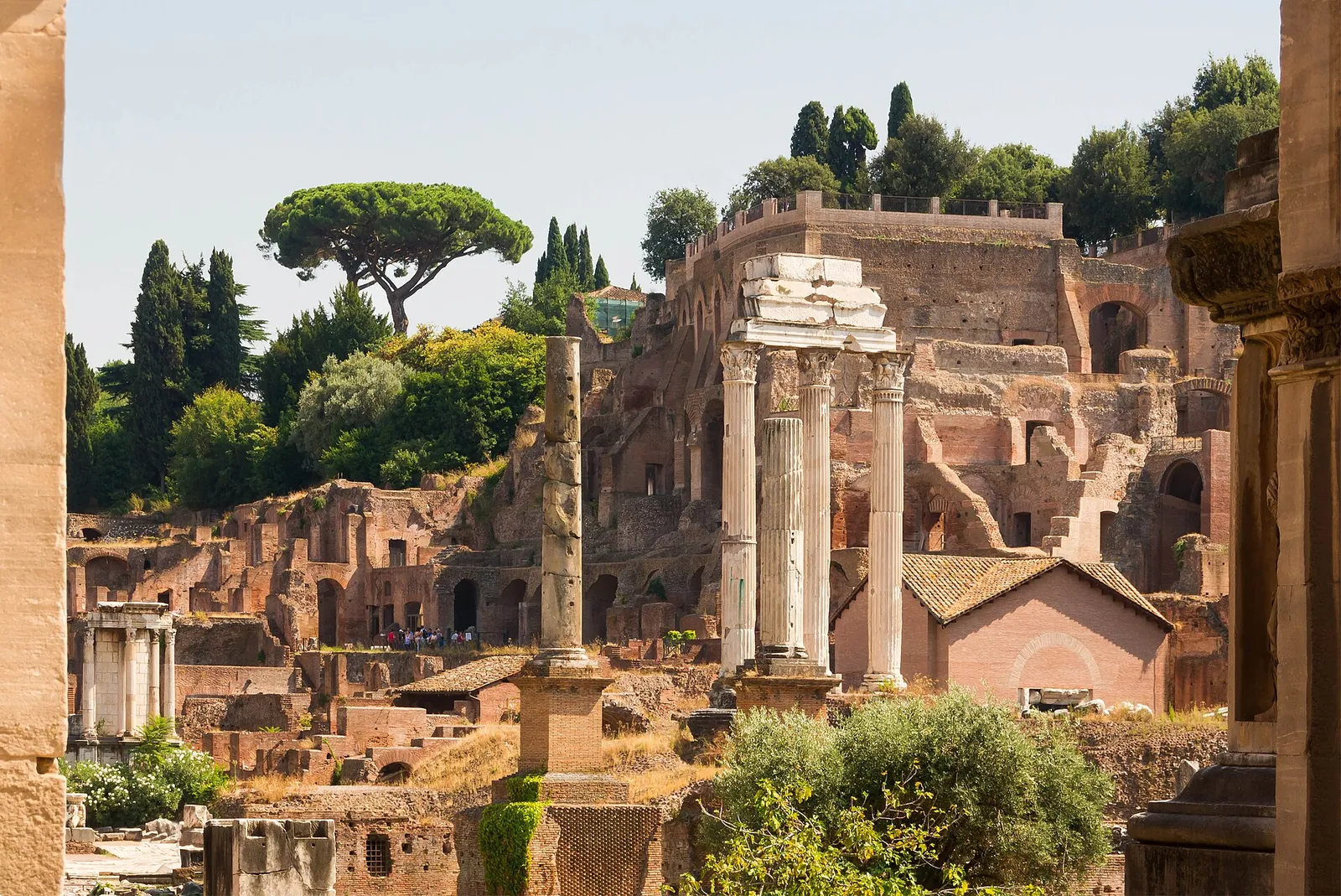 Columns and temples of the Roman Forum under blue sky