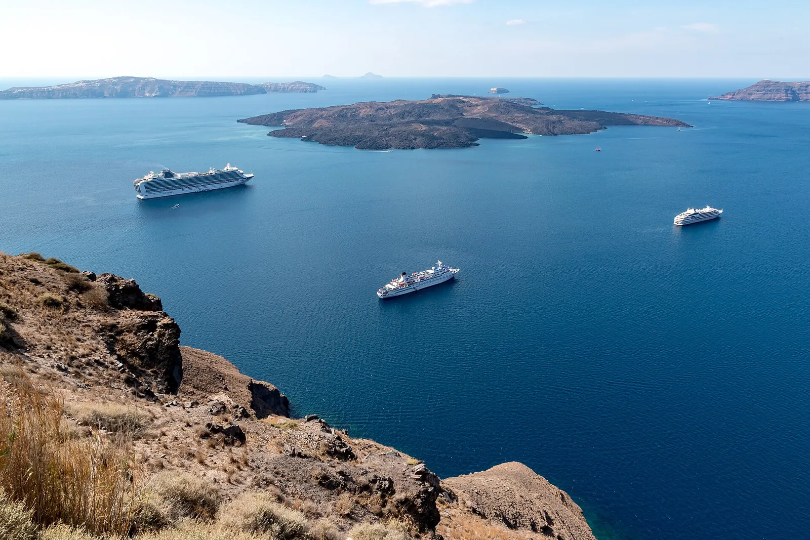 Ships anchored in the deep blue caldera below Fira