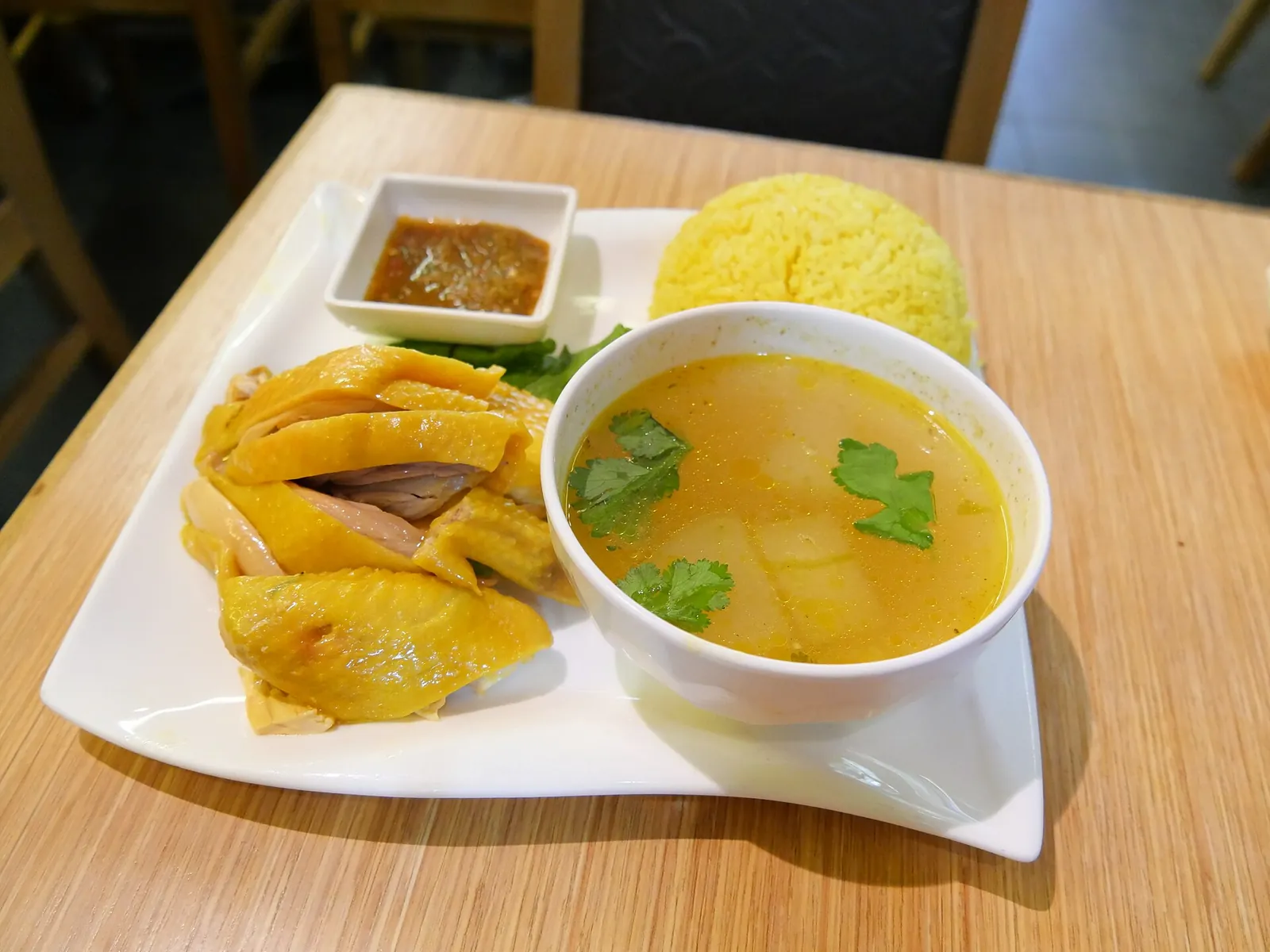 A plate of Hainanese chicken rice with soup