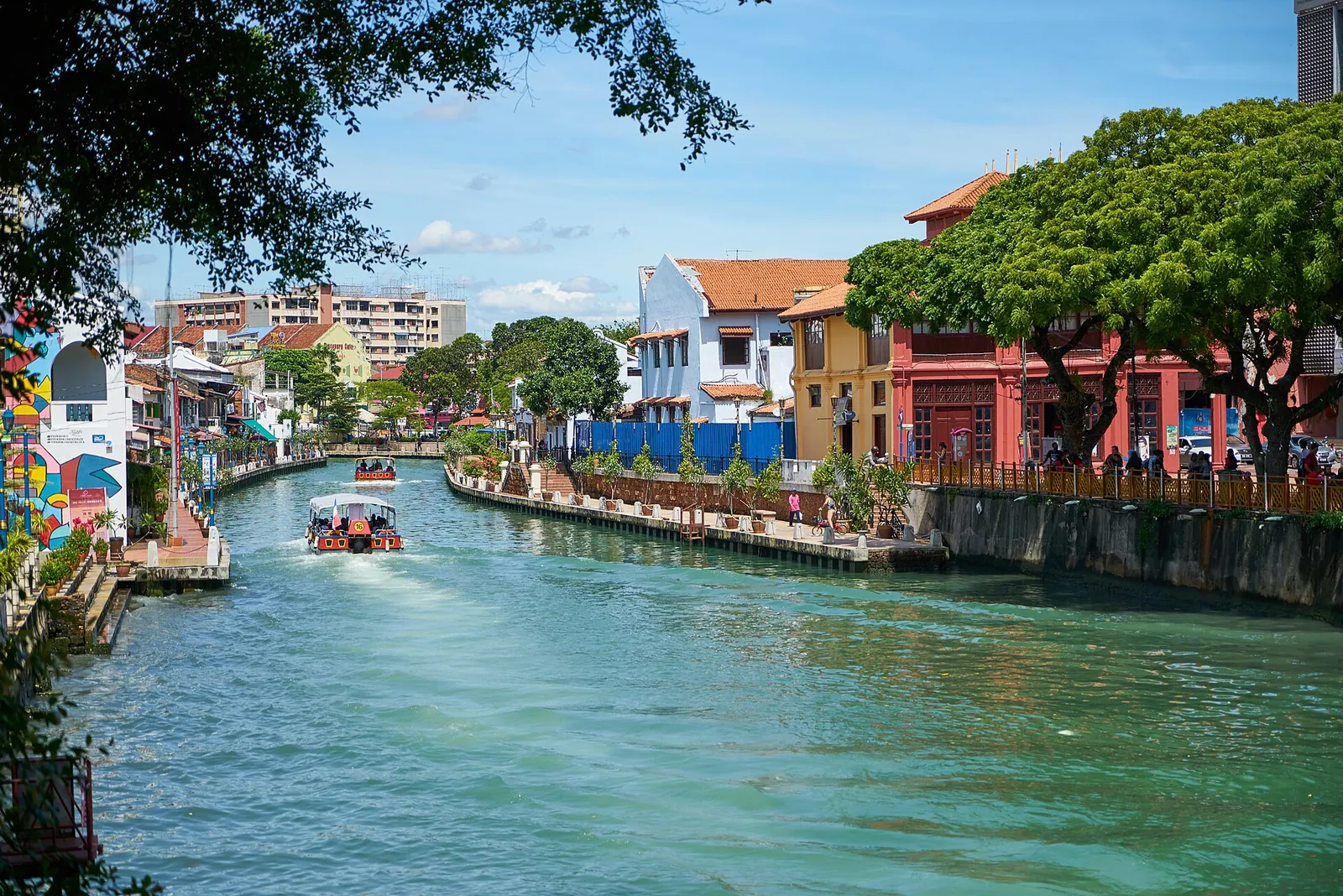 A cruise boat gliding along the colourful Malacca River