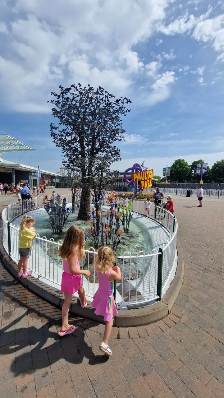 Two little girls seen from behind at the entrance to Paultons Park, on a sunny day