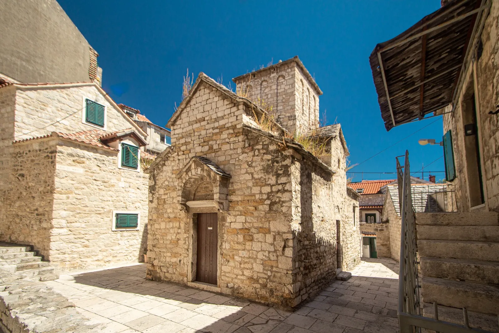 Sunny stone lanes and a small church in Varoš