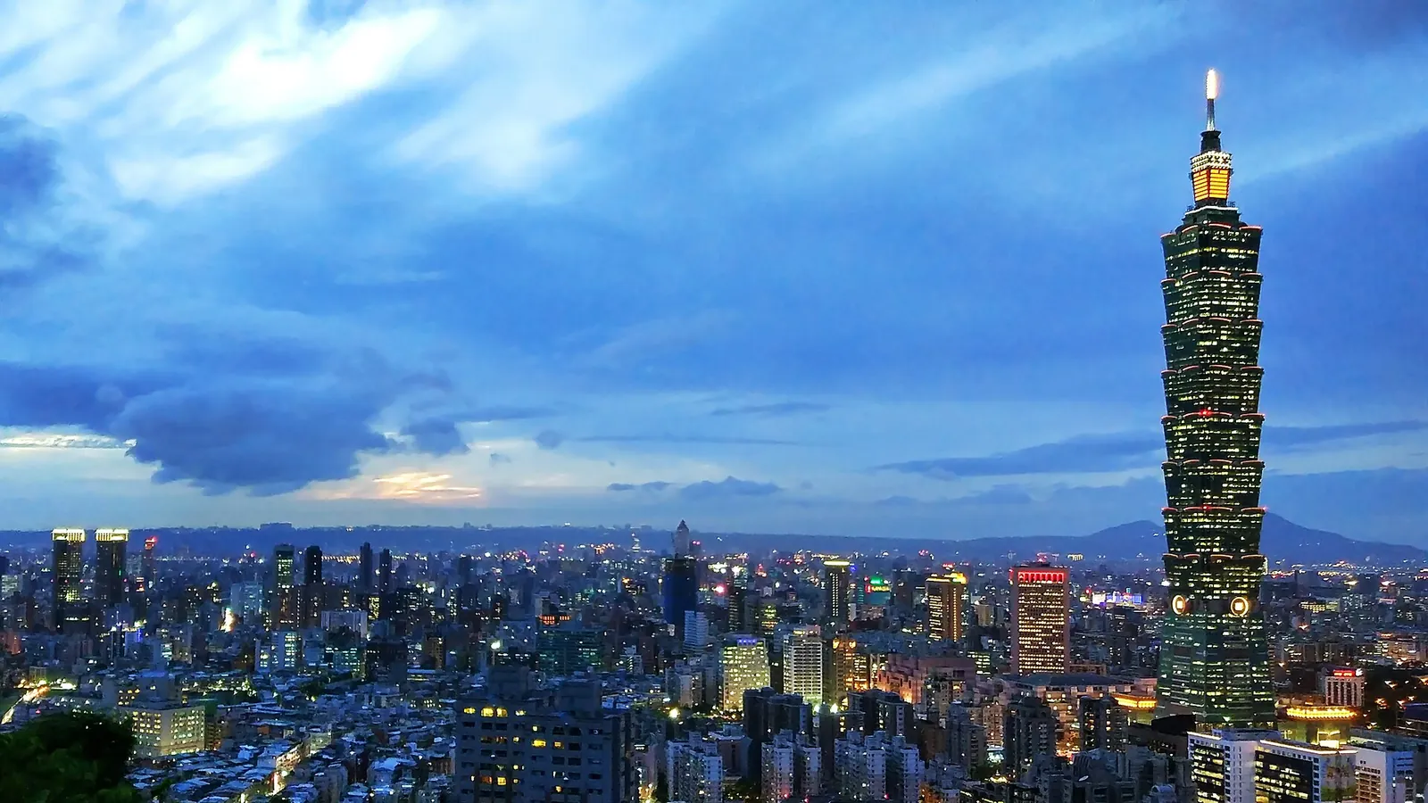 Taipei 101 glowing above the city at dusk