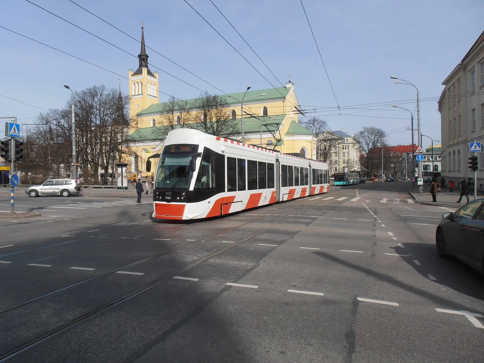 A modern tram passing St John's Church in Tallinn
