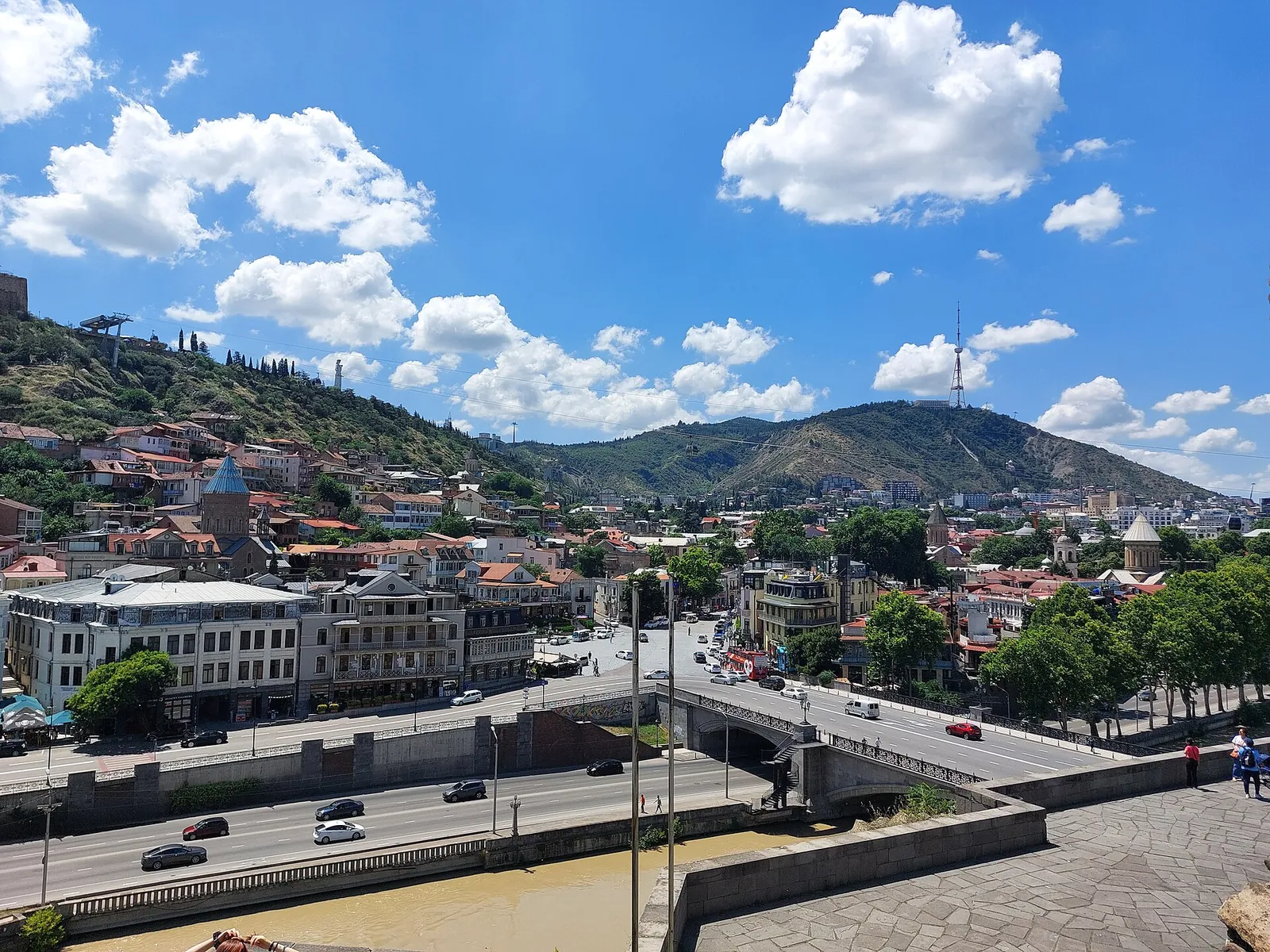 Mount Mtatsminda rising above central Tbilisi under blue skies