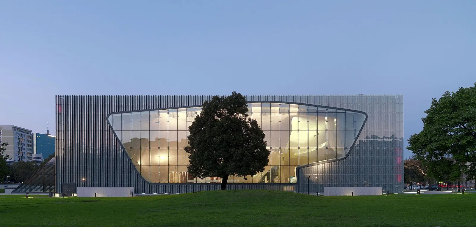 POLIN Museum glowing at dusk in Muranów