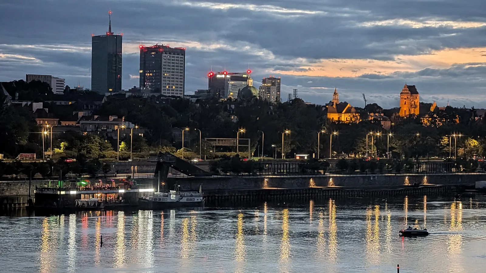 Warsaw's skyline and the Vistula lit up in the evening