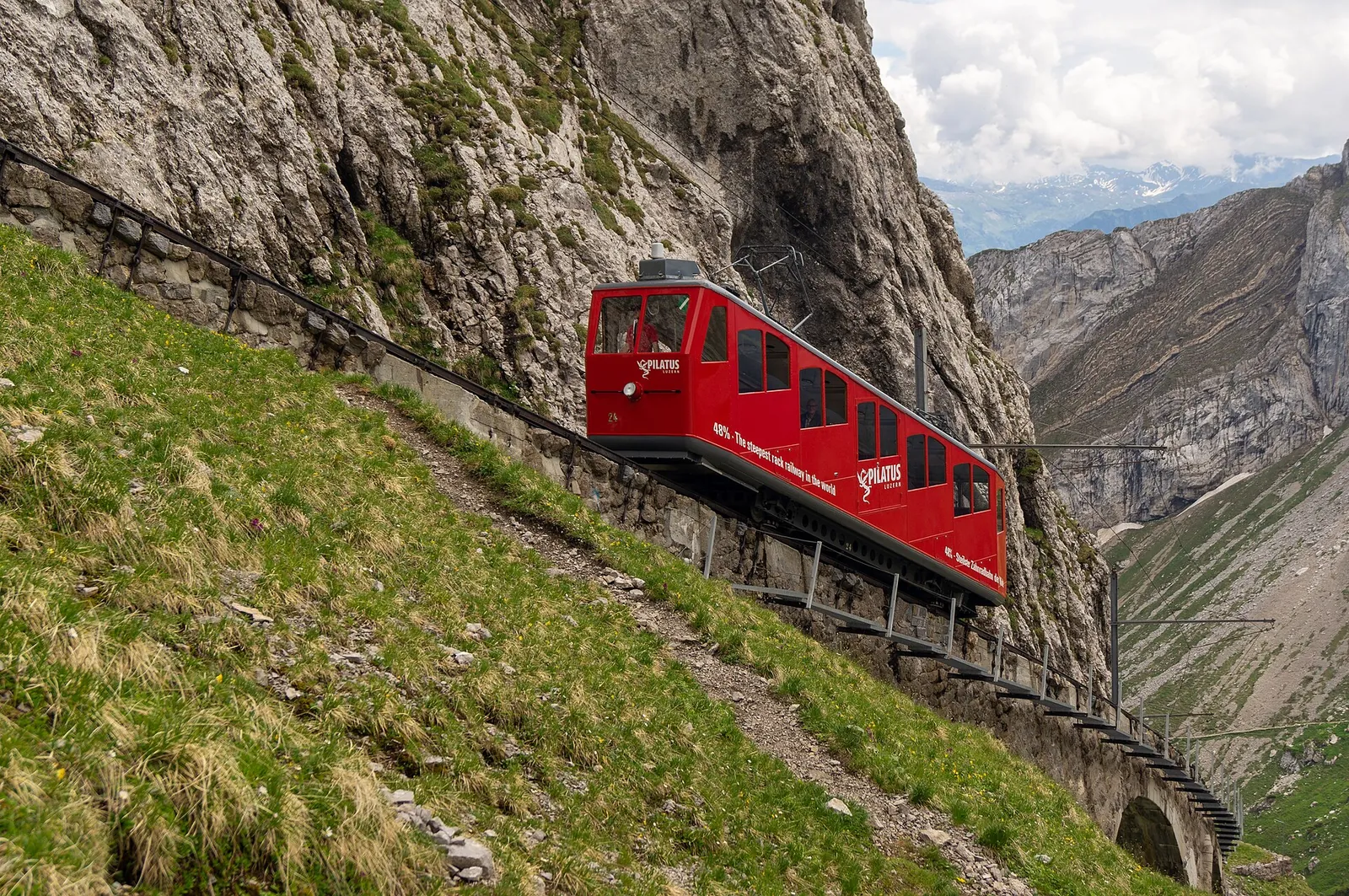 Red cogwheel train climbing the steep slopes of Pilatus